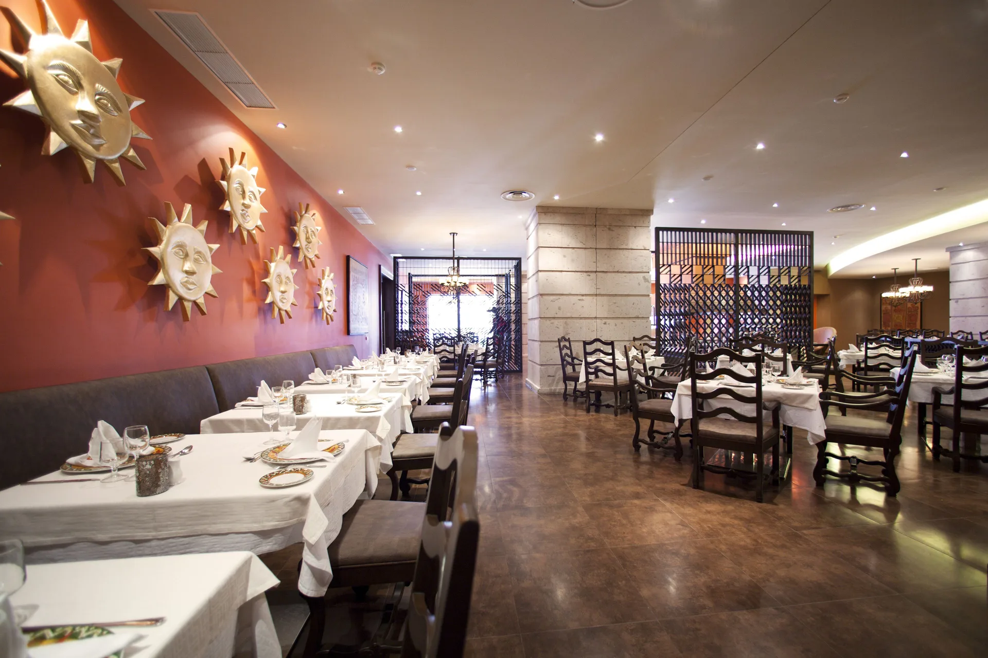 A Spanish-style dining room with sun wall art at Barceló Bávaro Palace.