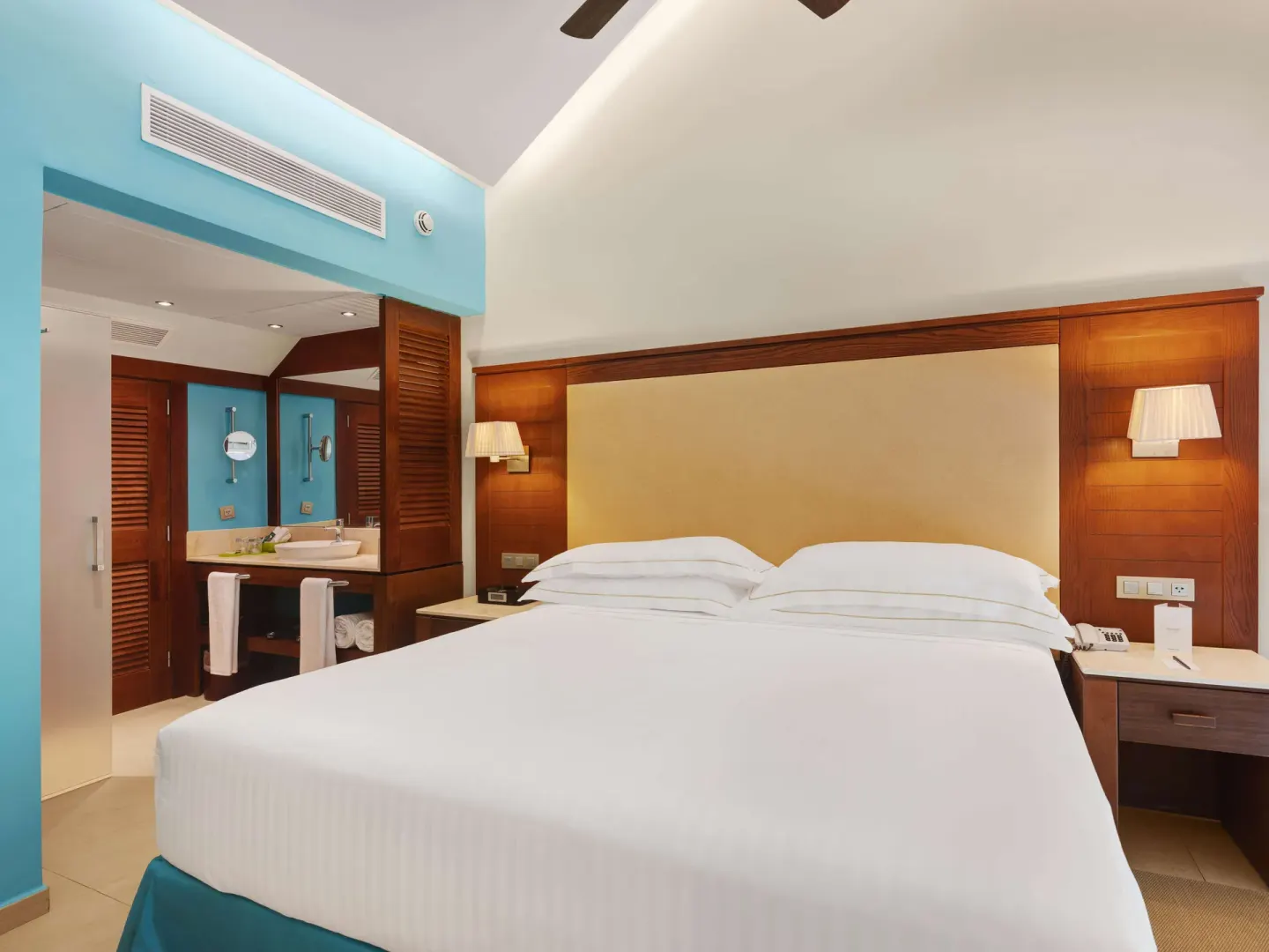 Family Duplex king bed with bedside lamps and open vanity area at Barceló Bávaro Palace.