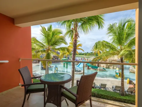Family Room balcony seating overlooking palms and water slides at Barceló Bávaro Palace.