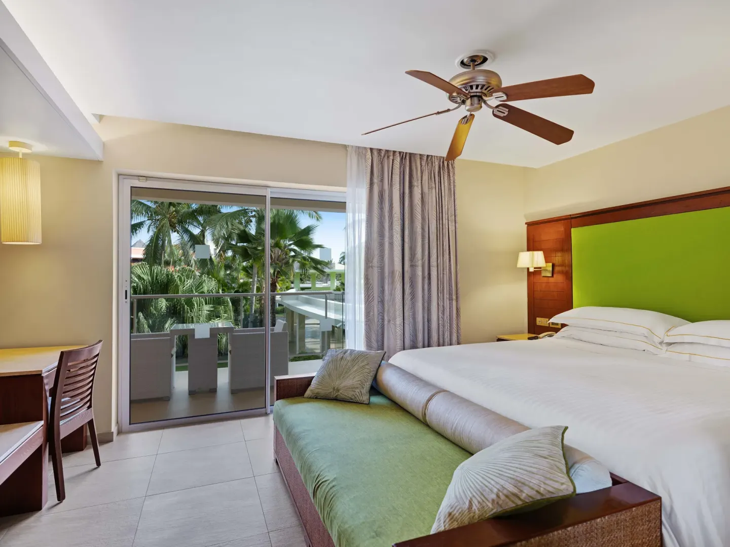 Family Room king bed and balcony with palm views at Barceló Bávaro Palace.