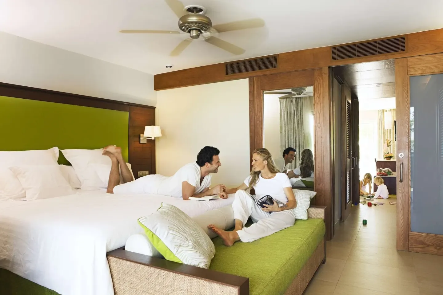 Family Room king bed with parents relaxing and children in adjoining space at Barceló Bávaro Palace.
