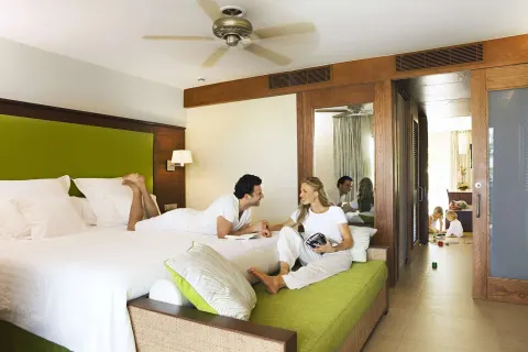 Family Room king bed with parents relaxing and children in adjoining space at Barceló Bávaro Palace.