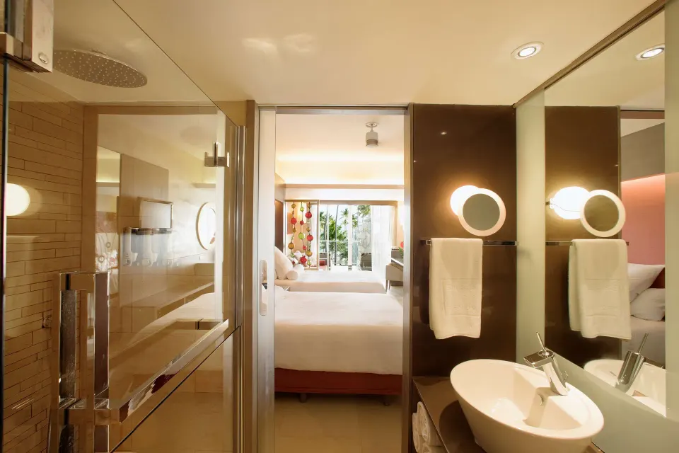 Junior Suite family Premium Level bathroom and bedroom with two beds at Barceló Bávaro Palace.