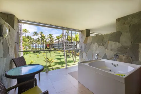 Junior Suite balcony with outdoor whirlpool tub, table, chairs, and garden view at Barceló Bávaro Palace.