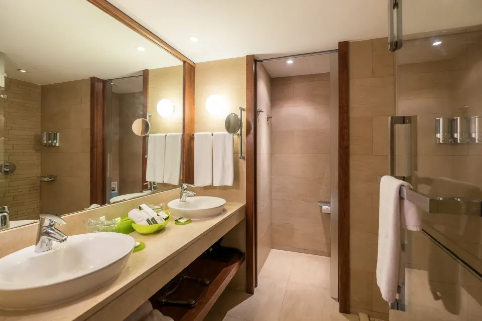 Suite bathroom with double sinks and glass shower at Barceló Bávaro Palace.
