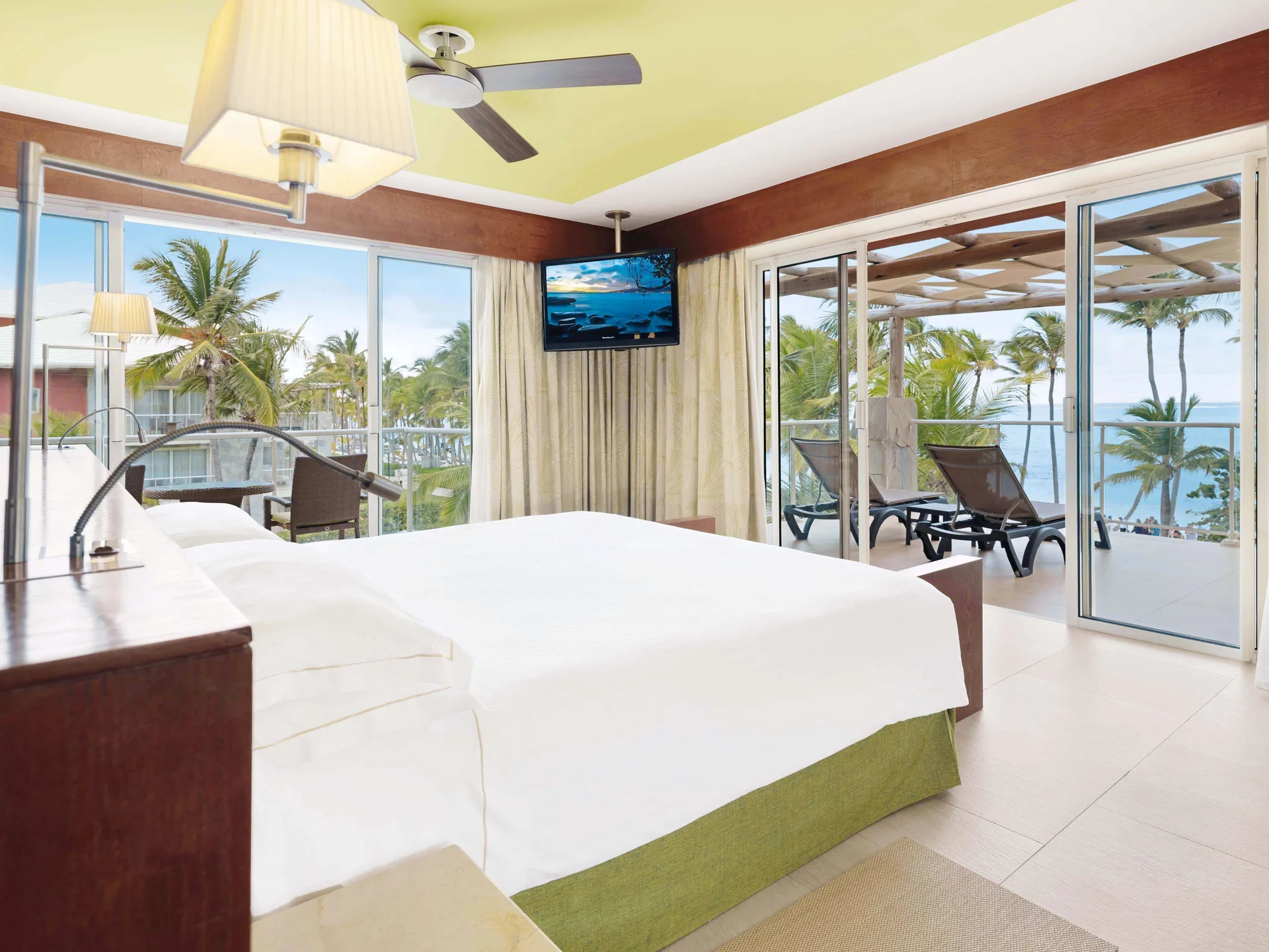 Sea view suite bedroom with balcony and king bed at Barceló Bávaro Palace.