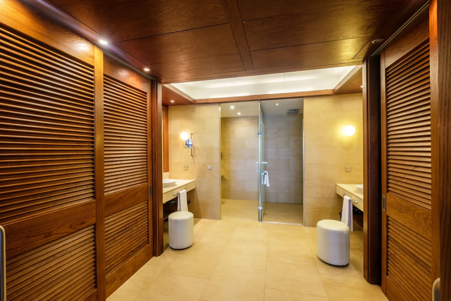 Sea View Suite bathroom at Barceló Bávaro Palace with wood closets, twin vanities, and glass shower.