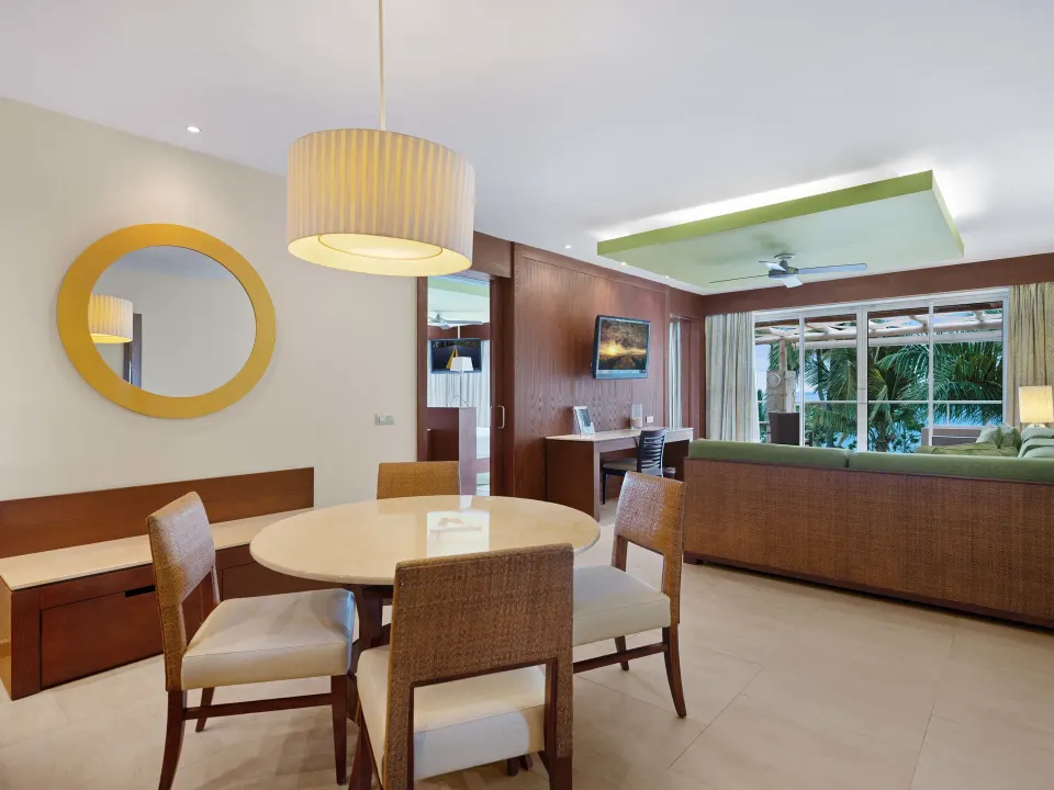 Sea View Suite dining and living area at Barceló Bávaro Palace with sofa, desk, and balcony doors.