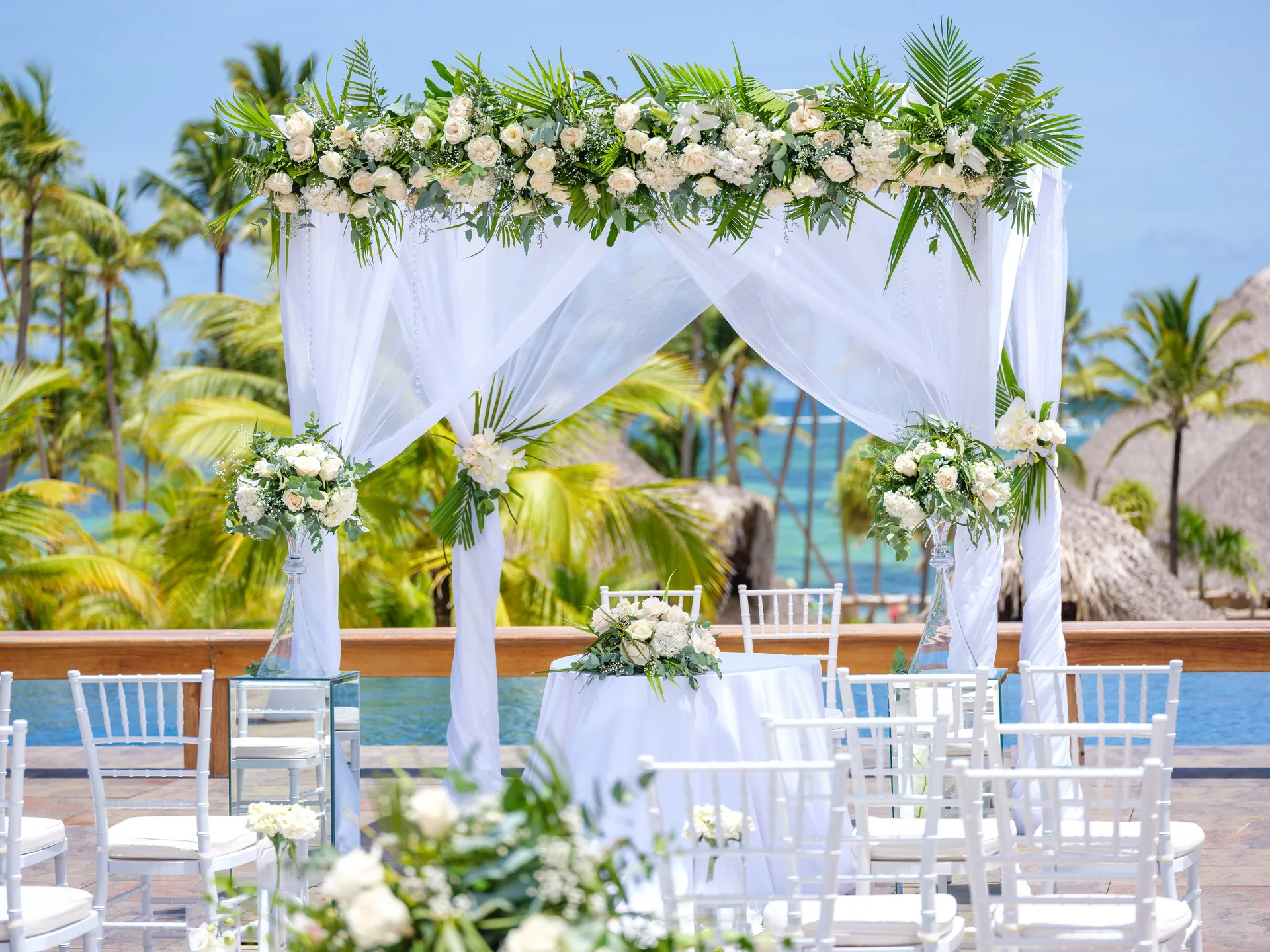 White floral wedding arch with chairs overlooking the sea at Barceló Bávaro Palace.