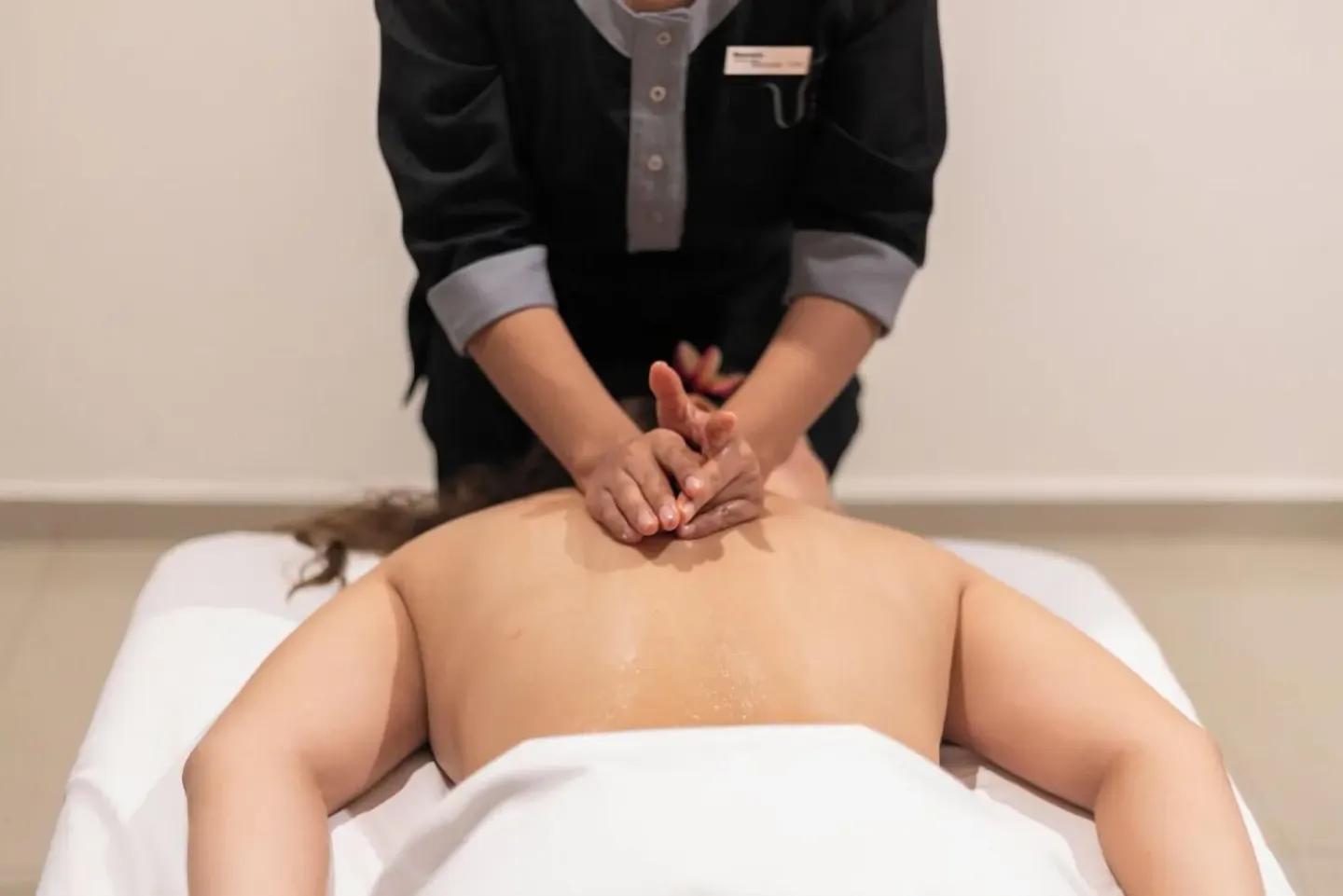 Therapist giving a back massage on a treatment table at Barceló Huatulco.