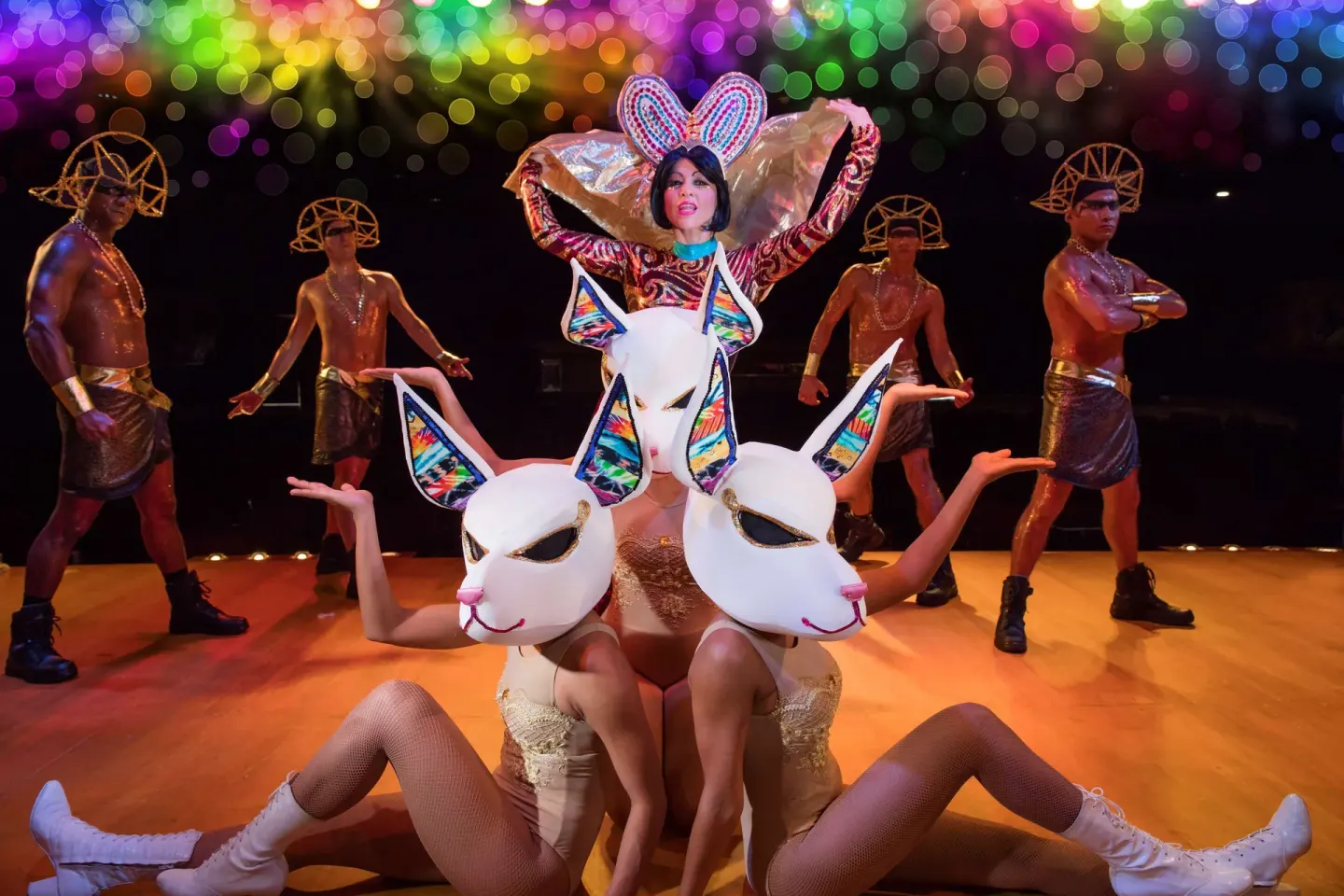 Costumed stage performers pose with white mask props at Barceló Huatulco.