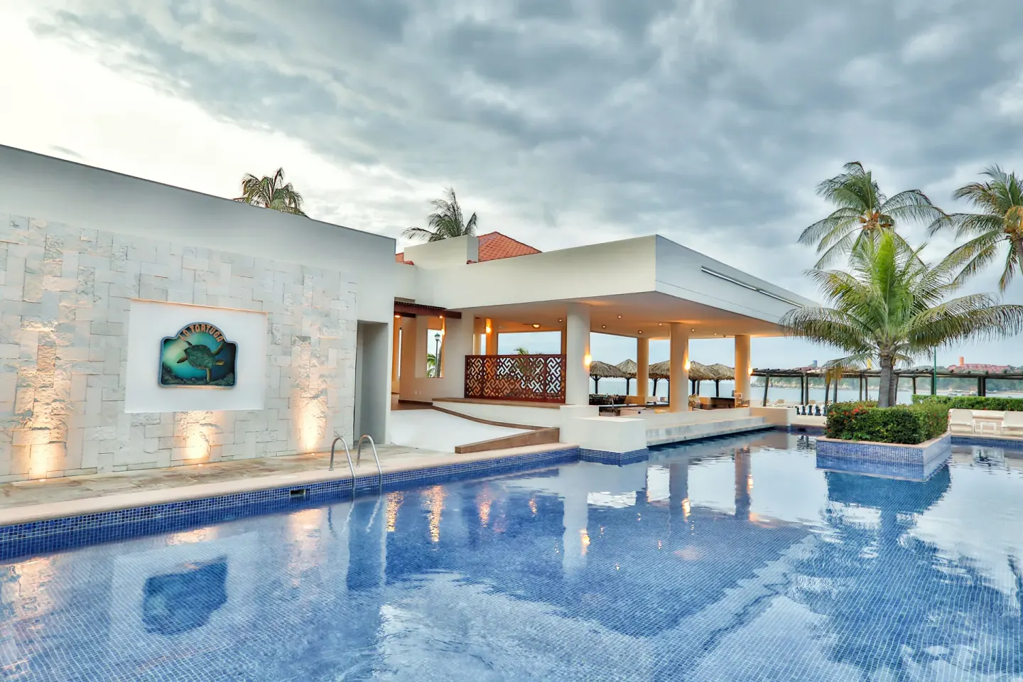 Poolside building and reflective swimming pool at Barceló Huatulco.