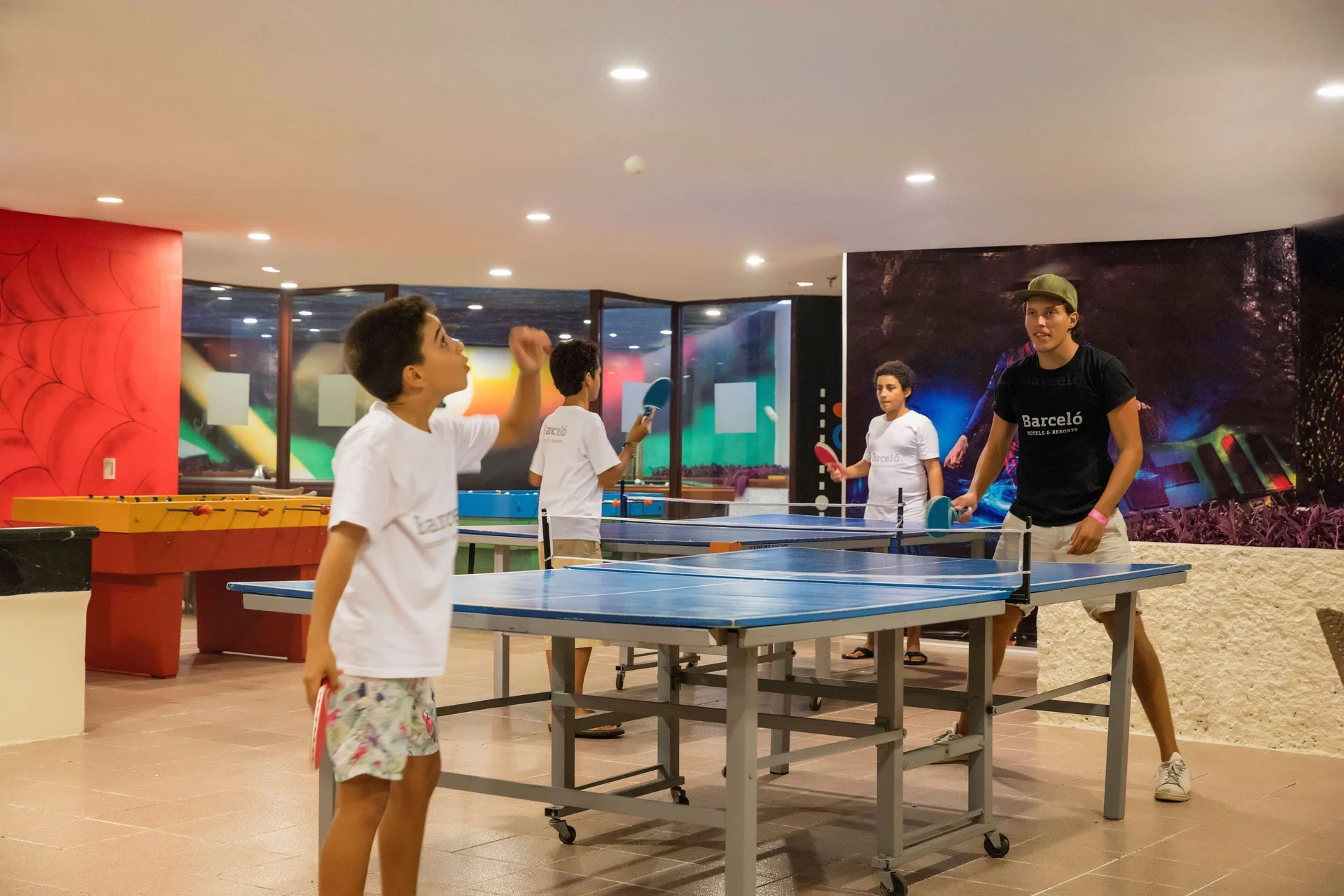 Guests play table tennis in an indoor recreation room at Barceló Huatulco.