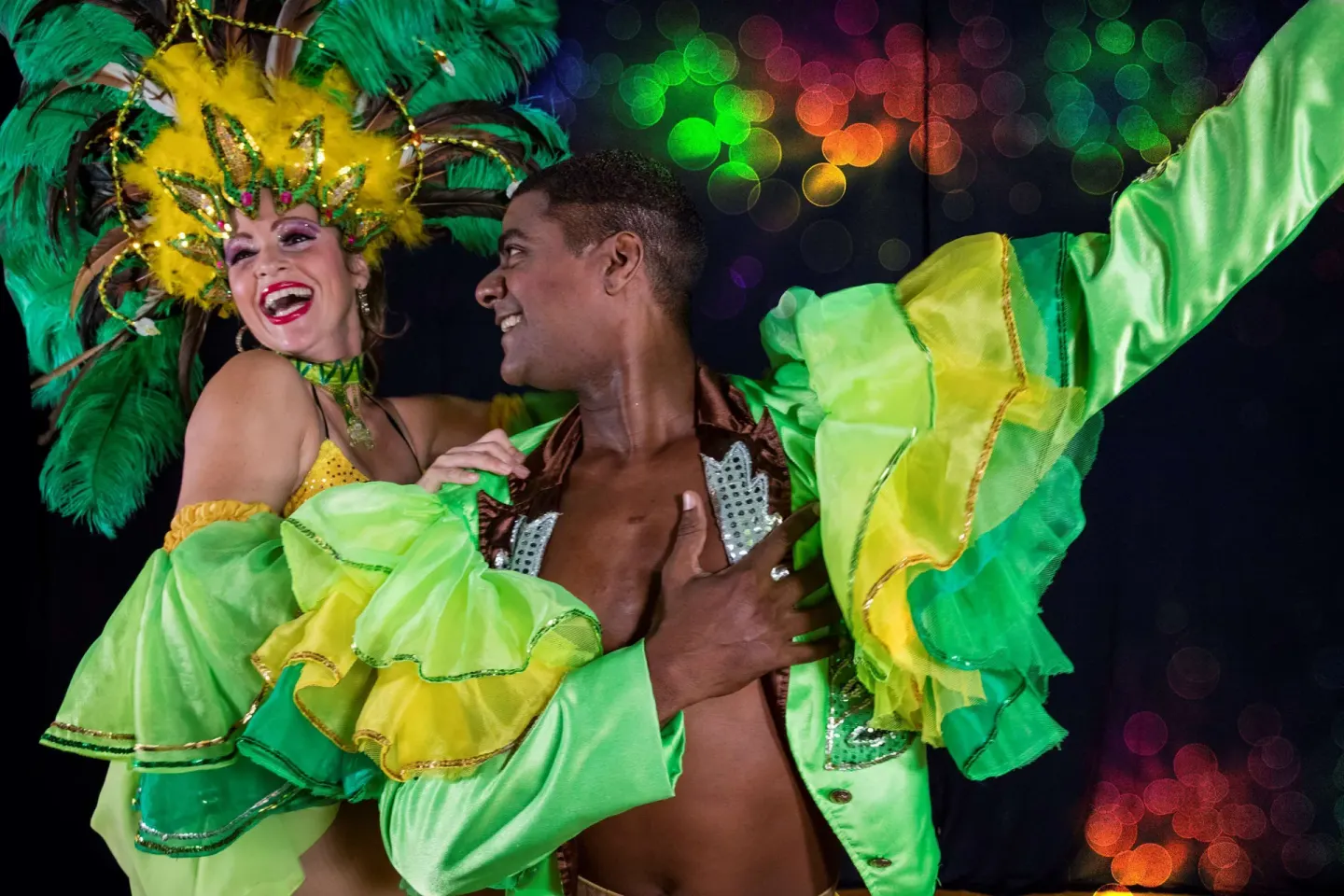 Two dancers in green feathered costumes perform at Barceló Huatulco.