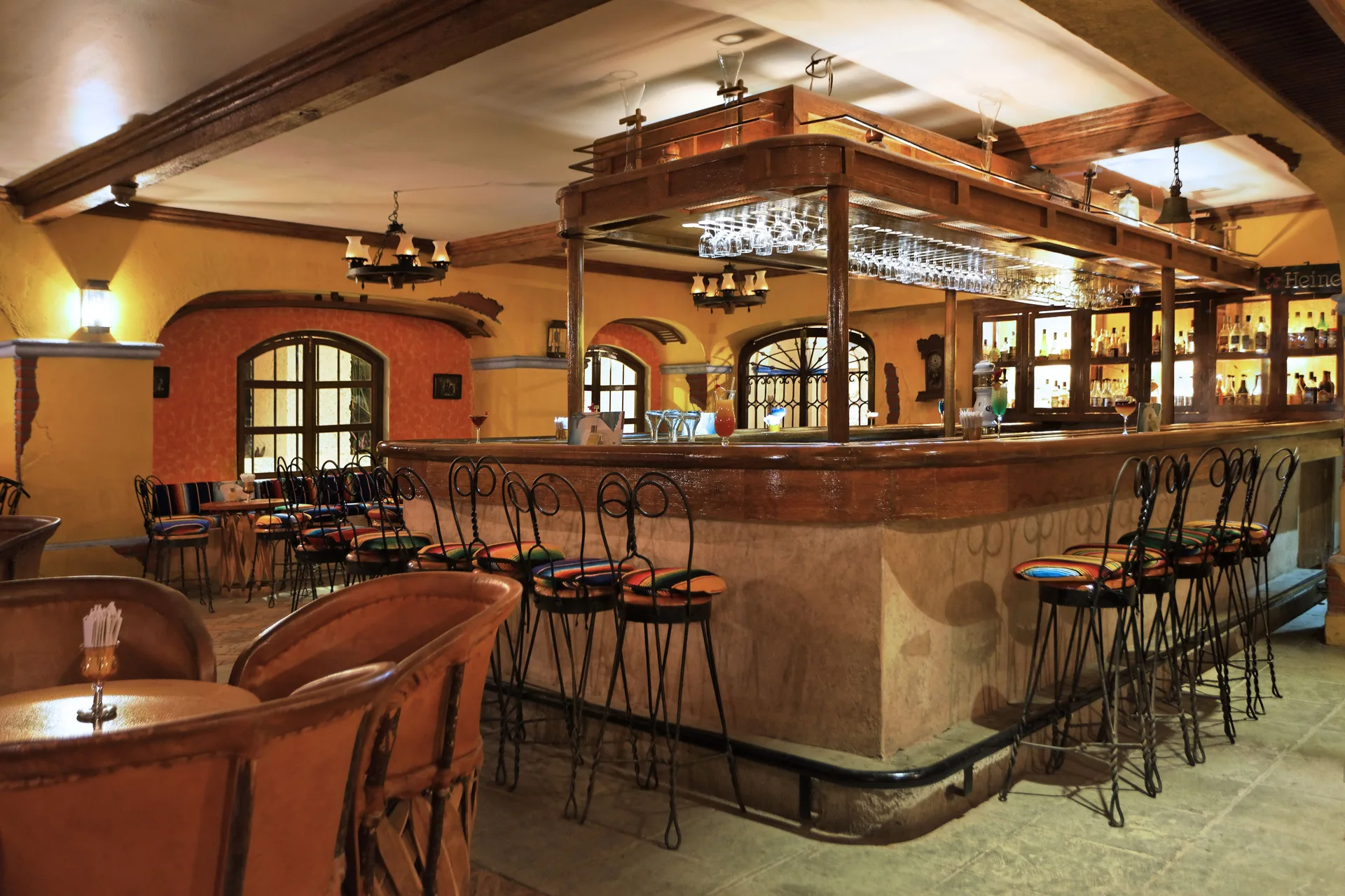 Cantina-style bar with high stools and warm lighting at Barceló Huatulco.