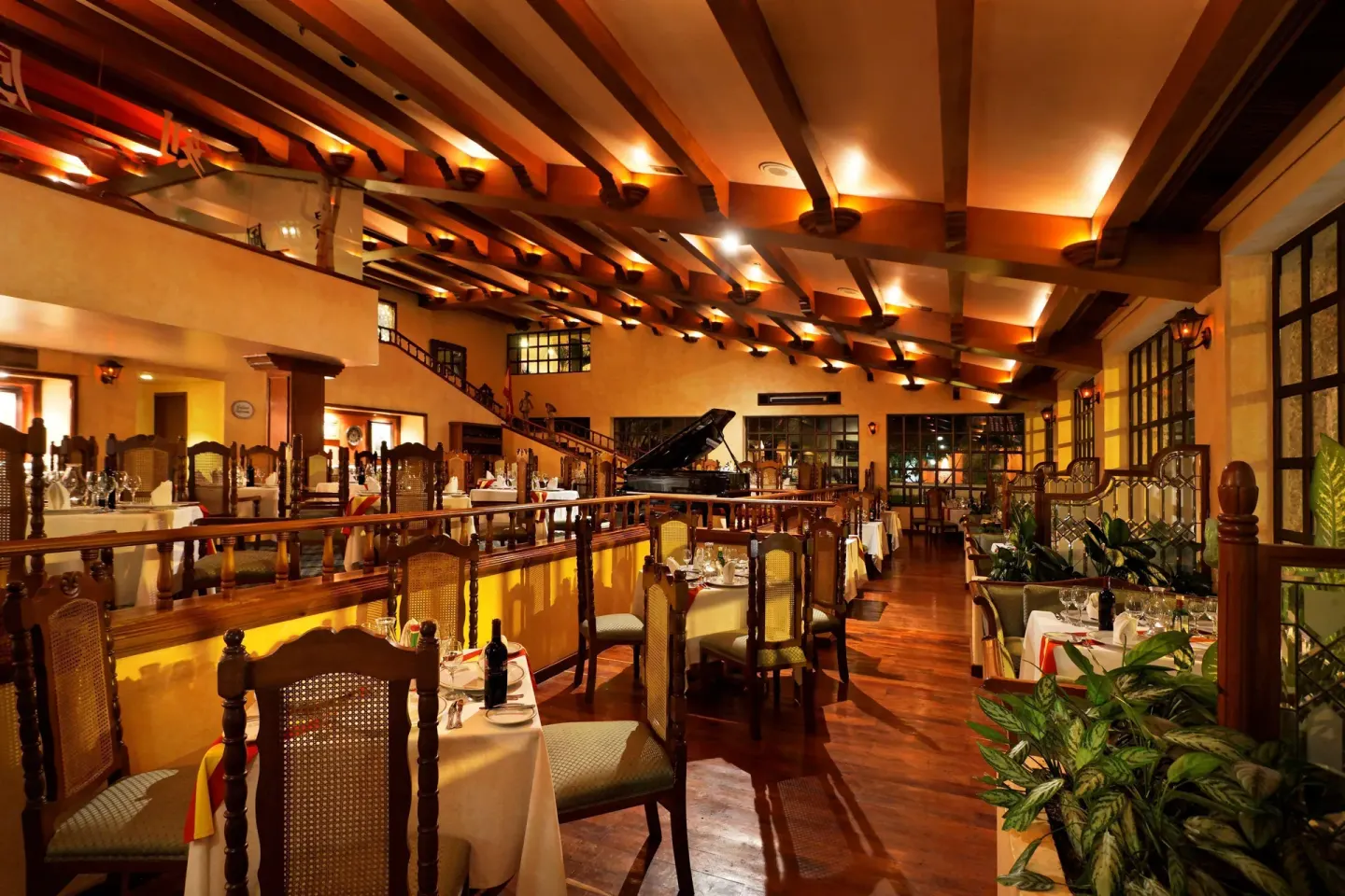 Traditional restaurant interior with piano and wood railings at Barceló Huatulco.