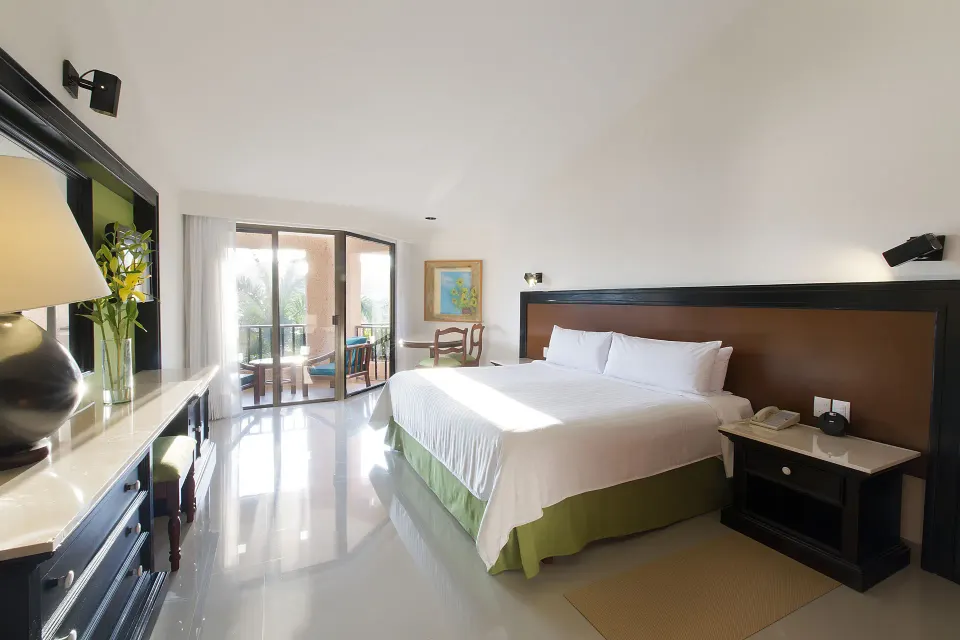 Deluxe Garden View room with a king bed and balcony seating at Barceló Huatulco.