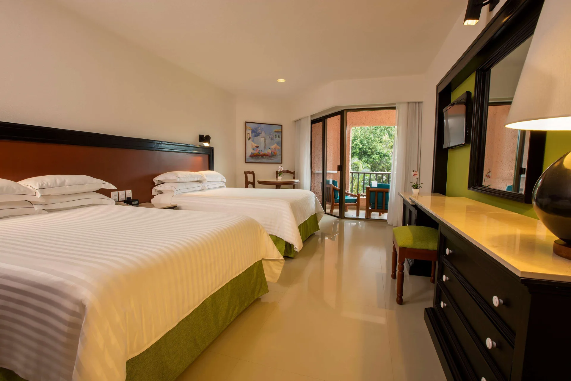 Deluxe Garden View room with two beds, dresser, and balcony at Barceló Huatulco.