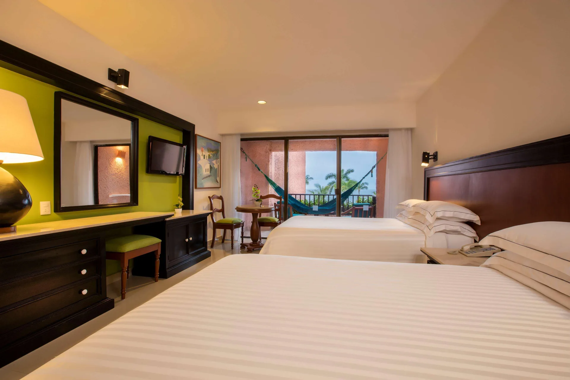 Deluxe Partial Ocean View room with two beds and balcony hammock at Barceló Huatulco.