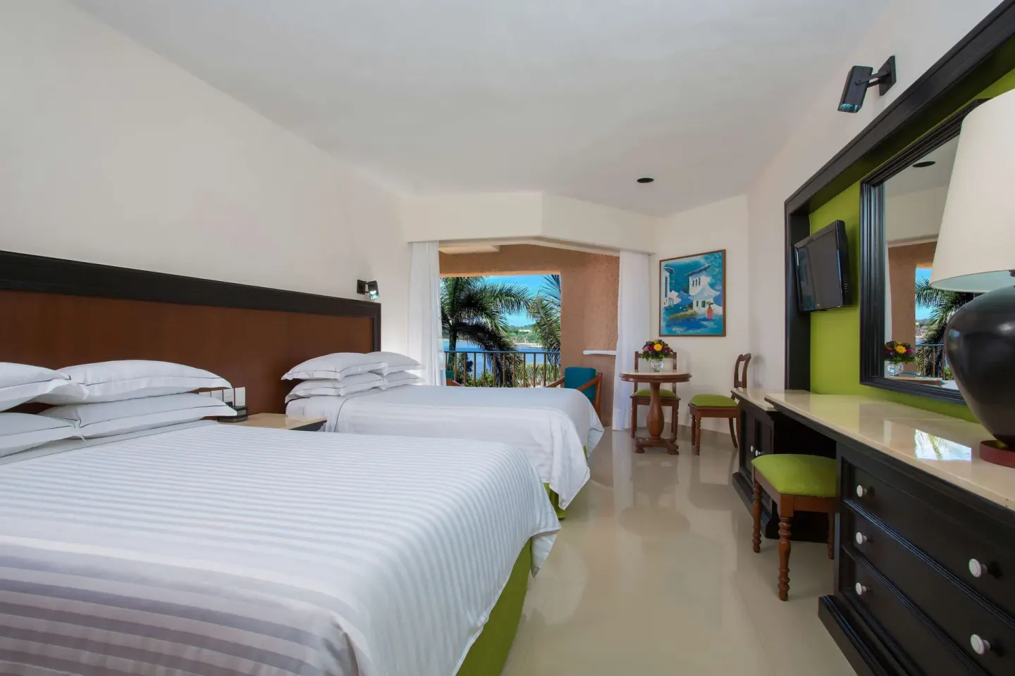 Deluxe Partial Ocean View room with two beds, dresser, and balcony at Barceló Huatulco.