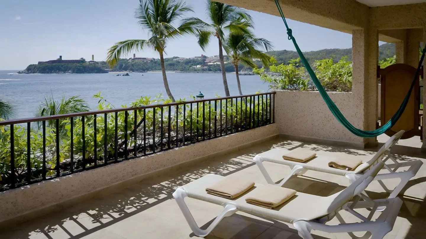 Sea-facing terrace with loungers and hammock for a Deluxe room at Barceló Huatulco.