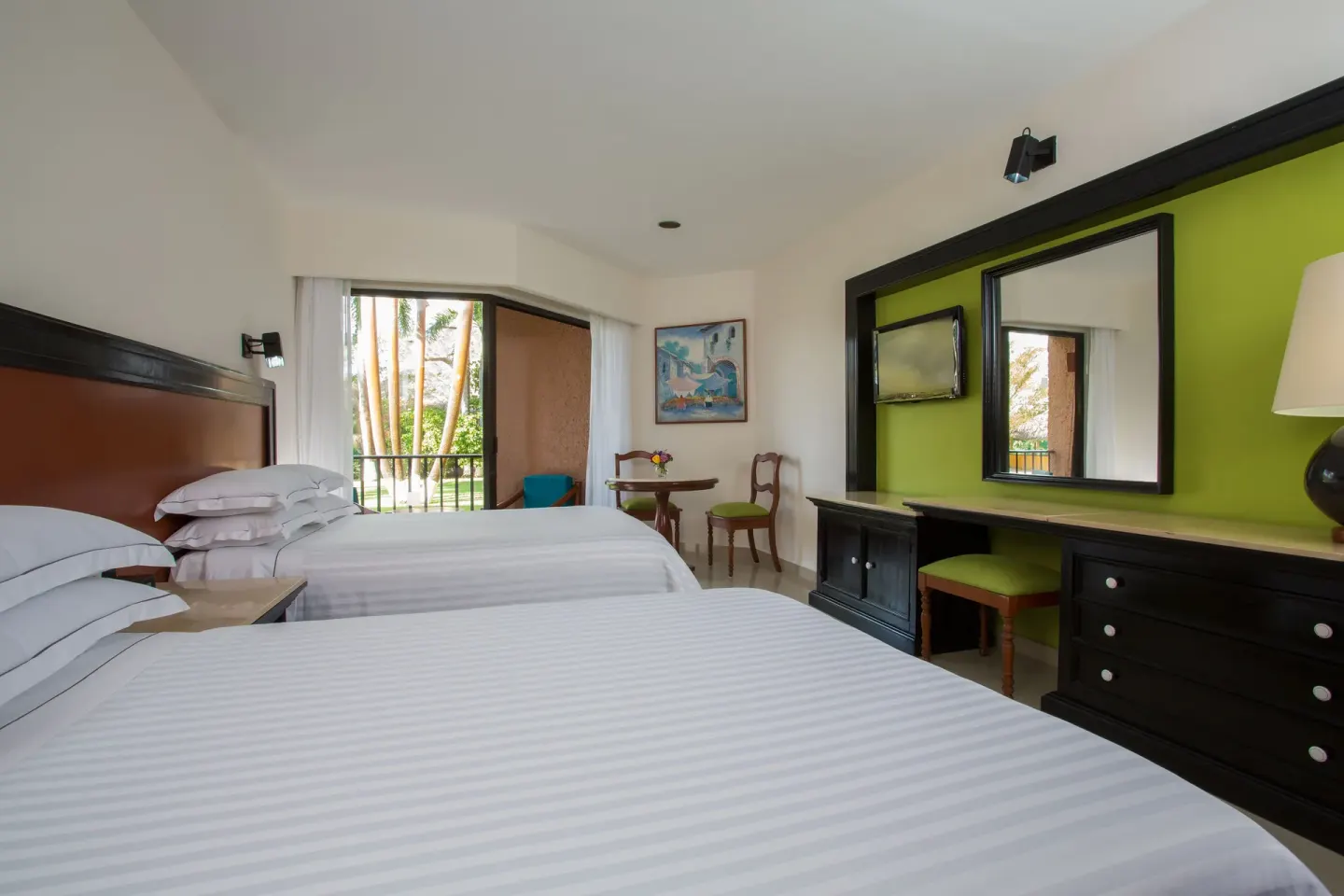 Deluxe Room with Garden View showing two beds and balcony at Barceló Huatulco.