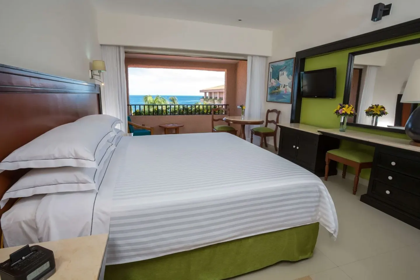 Premium Level Sea Front View Deluxe Suite king bed with sea-view balcony at Barceló Huatulco.