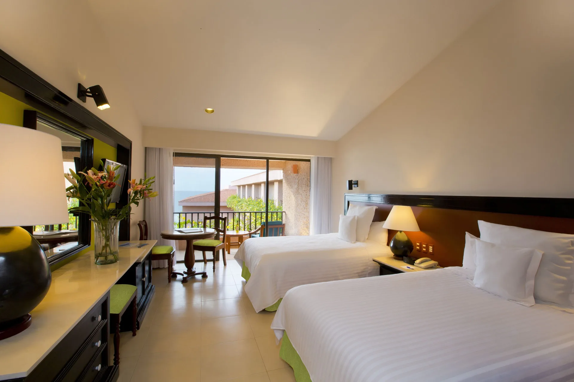 Premium Level Sea Front View Deluxe Suite with two beds and dresser at Barceló Huatulco.