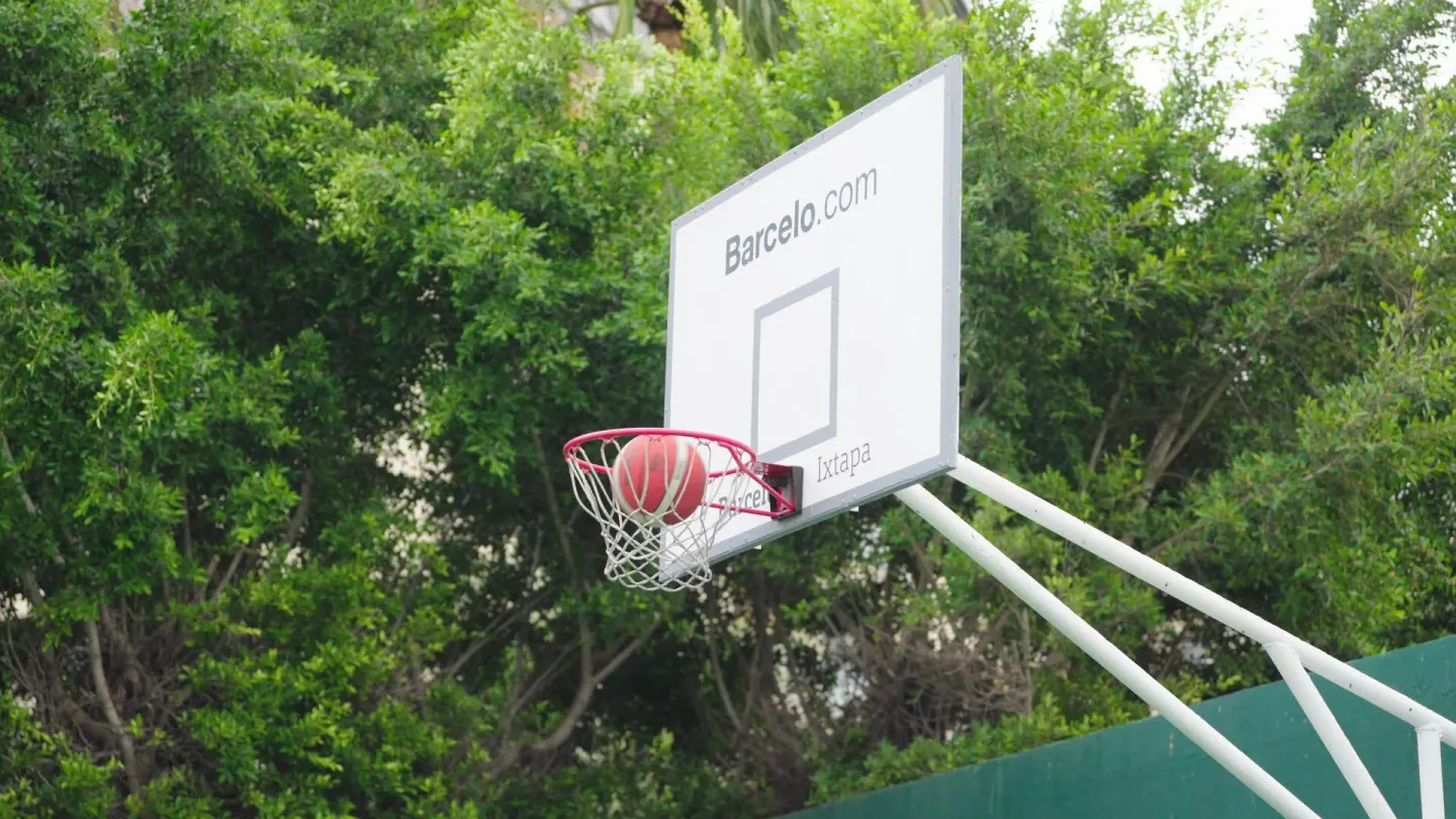 A basketball drops through an outdoor hoop on the sports court at Barceló Ixtapa.