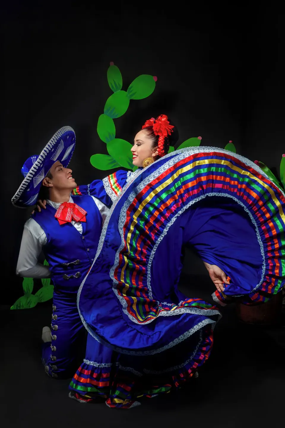 A dance couple poses in vivid blue folkloric costumes at Barceló Ixtapa.