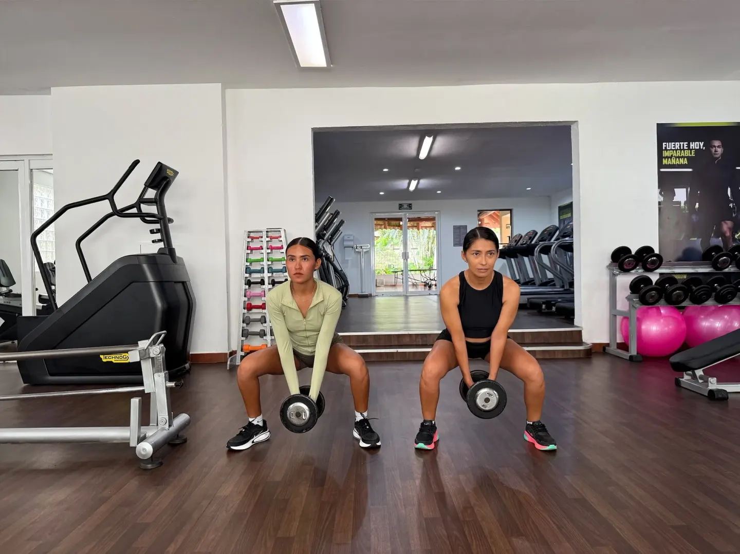 Two guests lift dumbbells in the fitness center at Barceló Ixtapa.