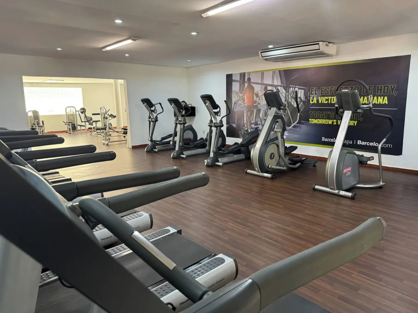 Cardio machines and treadmills face a wall graphic in the fitness center at Barceló Ixtapa.