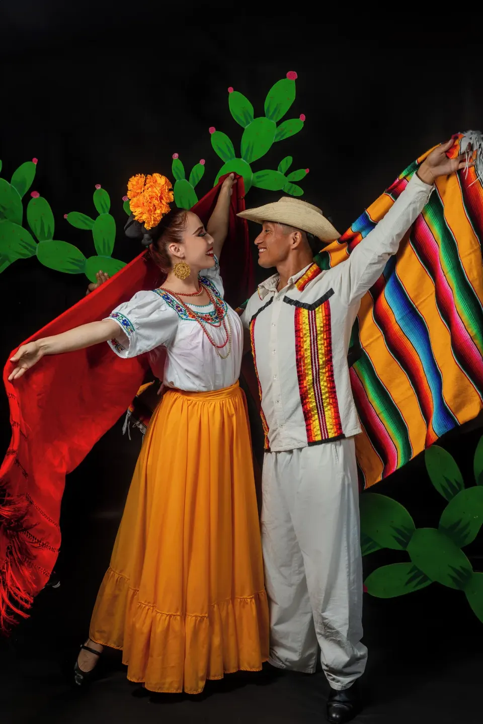 Two folkloric dancers pose in colorful costumes on a stage at Barceló Ixtapa.