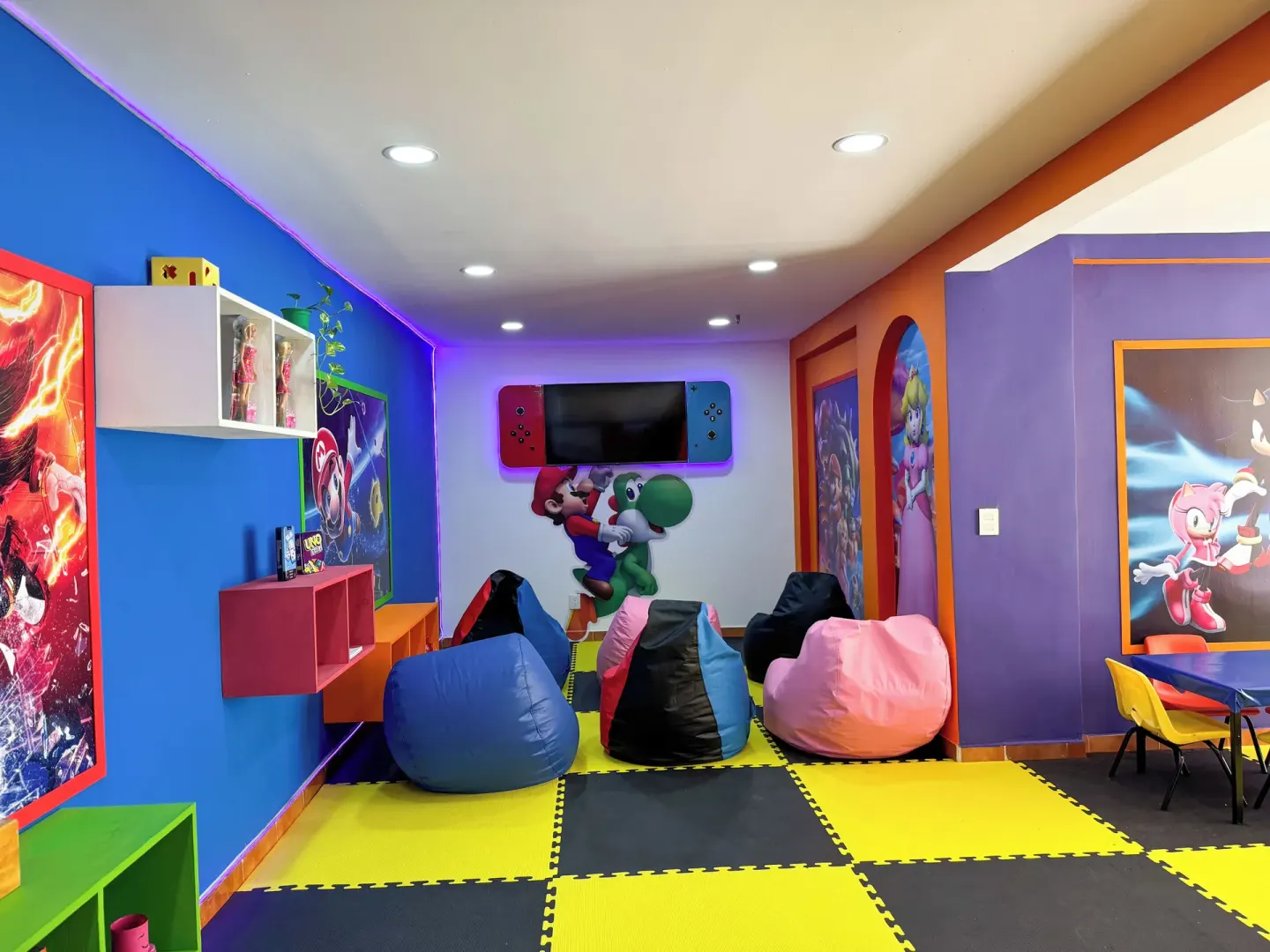 Colorful kids' lounge with beanbags, wall art, and play mats at Barceló Ixtapa.