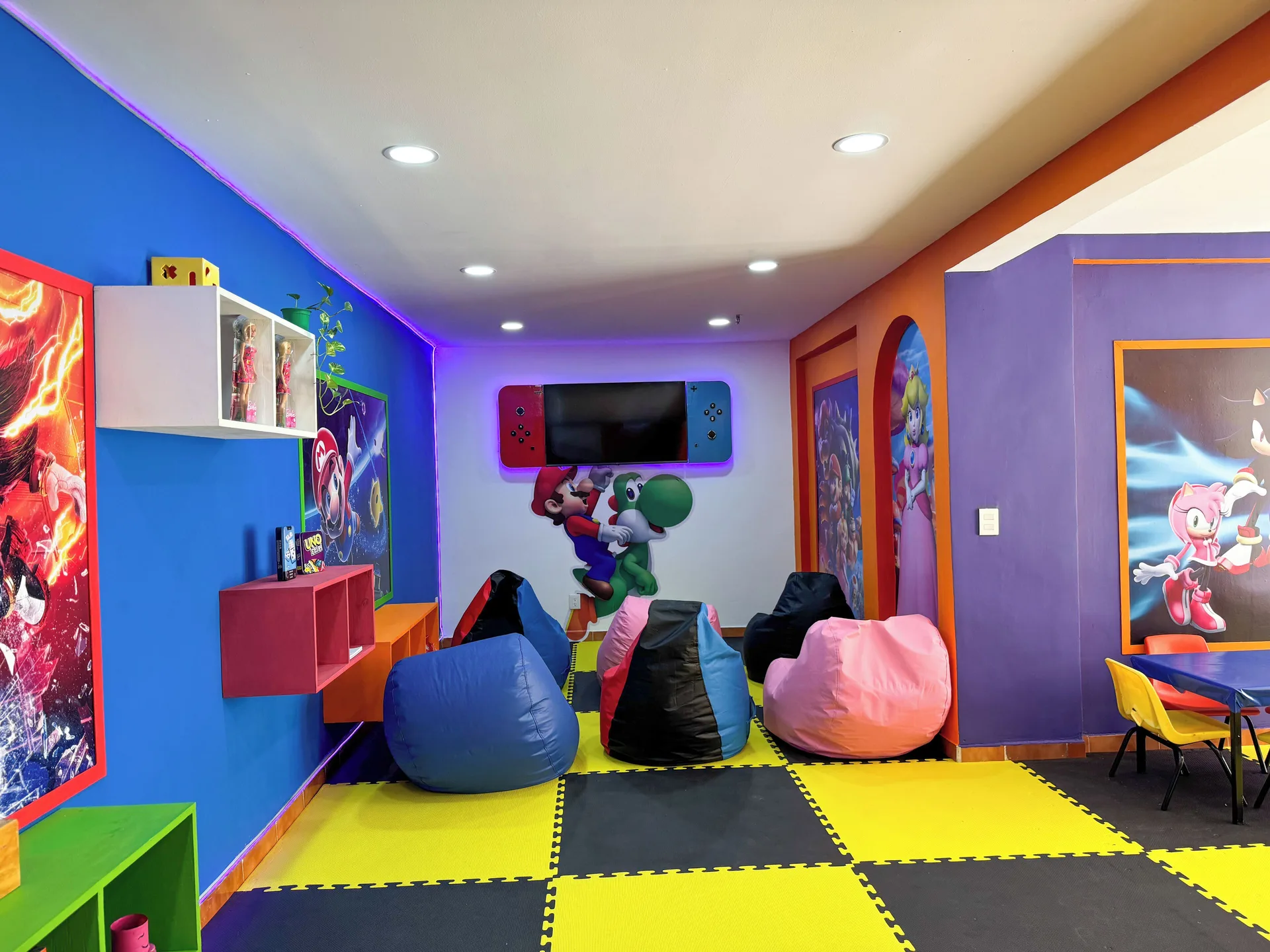 Colorful kids' lounge with beanbags, wall art, and play mats at Barceló Ixtapa.