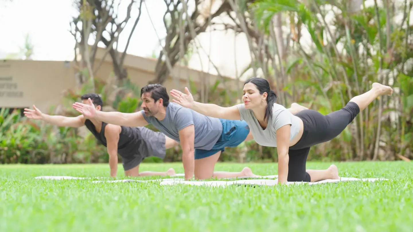 Guests practice yoga on a lawn at Barceló Ixtapa.