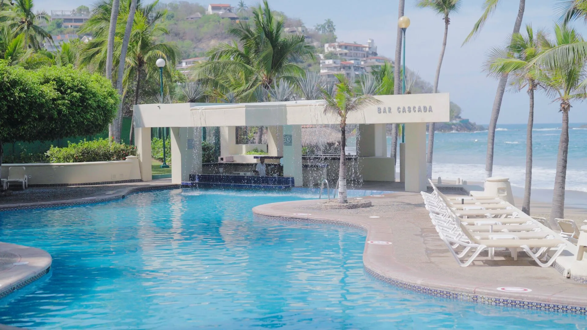 Bar Sanca sits beside a curved pool and rows of loungers at Barceló Ixtapa.