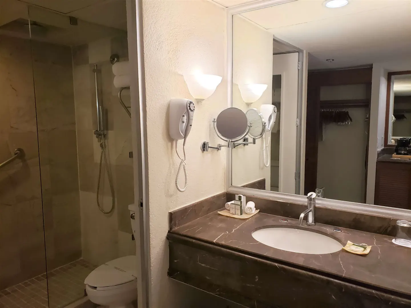 Family Villa bathroom at Barceló Ixtapa with sink vanity, mirror, hair dryer, and glass shower.