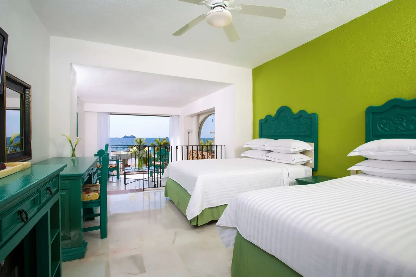 Family Villa bedroom with two double beds and a balcony overlooking the ocean at Barceló Ixtapa.