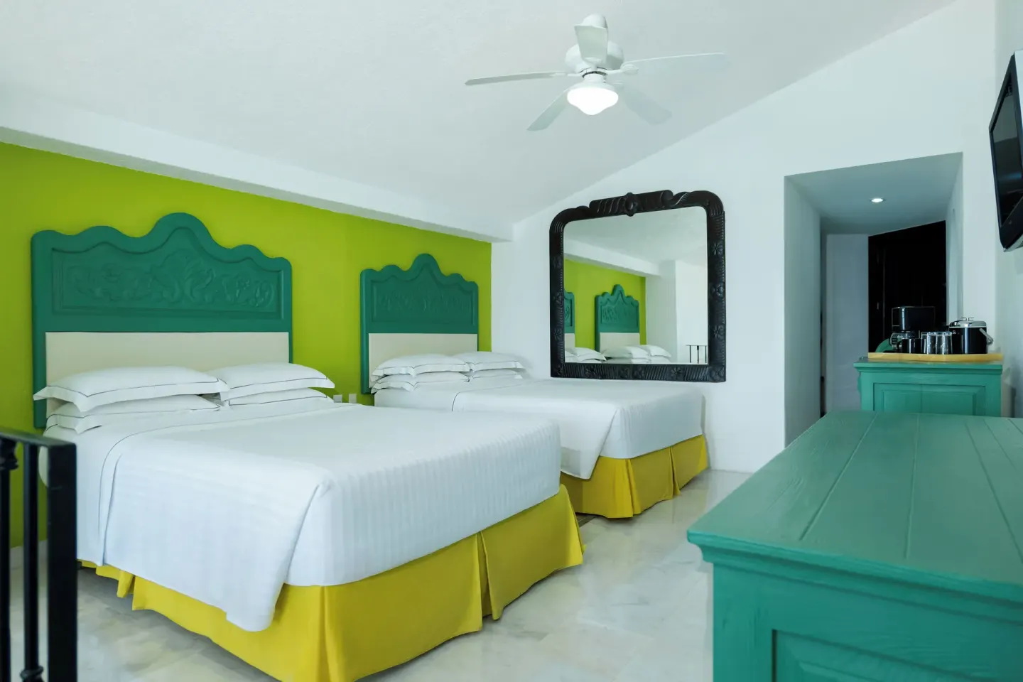 Family Villa bedroom with two double beds, wall mirror, and teal dresser at Barceló Ixtapa.