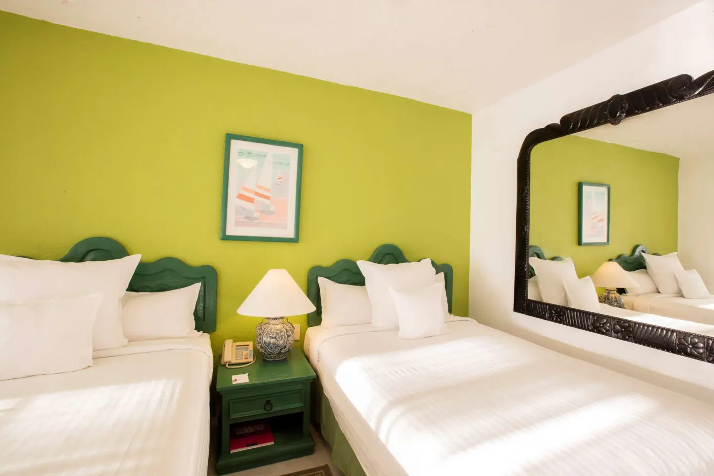 Family Villa two-bed sleeping area with green accent wall and large mirror at Barceló Ixtapa.