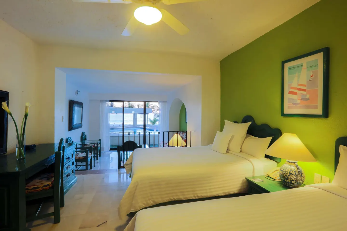 Family Villa bedroom with two beds, bedside lamp, and sliding doors at Barceló Ixtapa.