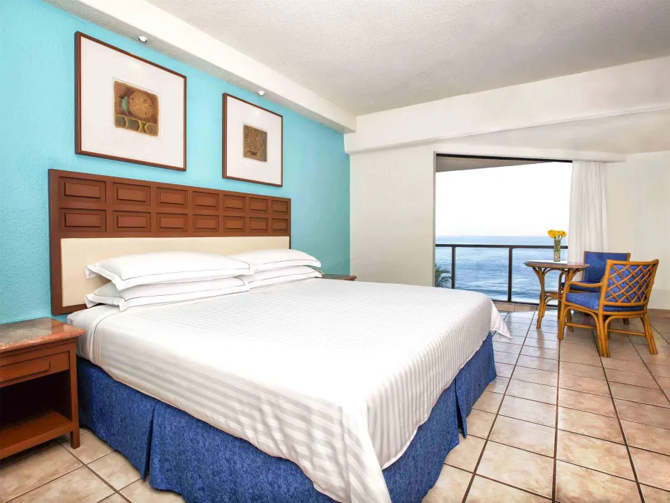 Superior Room Sea View with king bed, balcony seating and ocean view at Barceló Ixtapa.