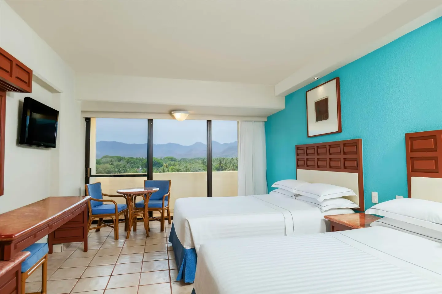Superior Room with two double beds, desk, and wide window at Barceló Ixtapa.
