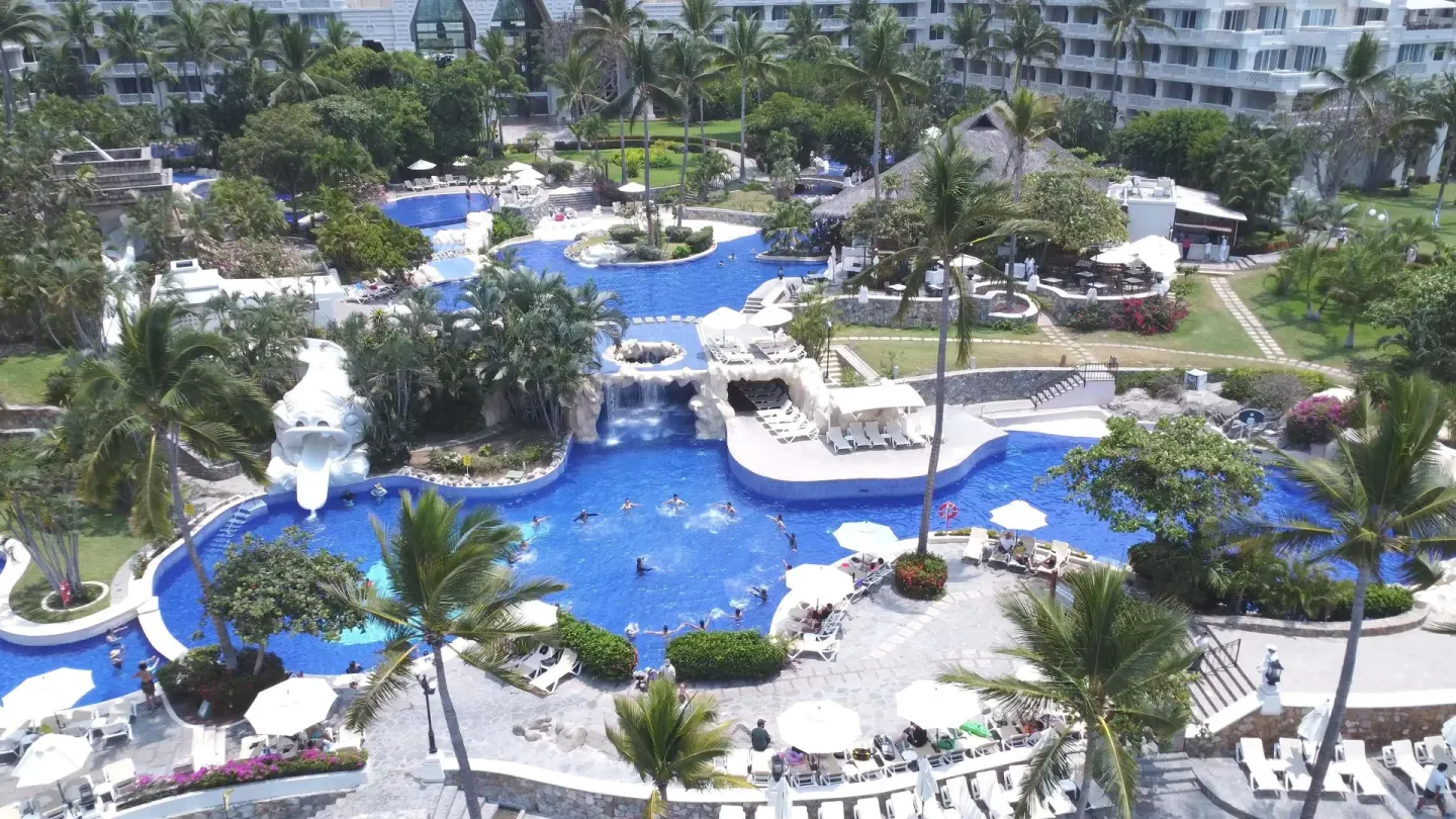 Aerial view of connected pools, palms, and loungers at Barceló Karmina.