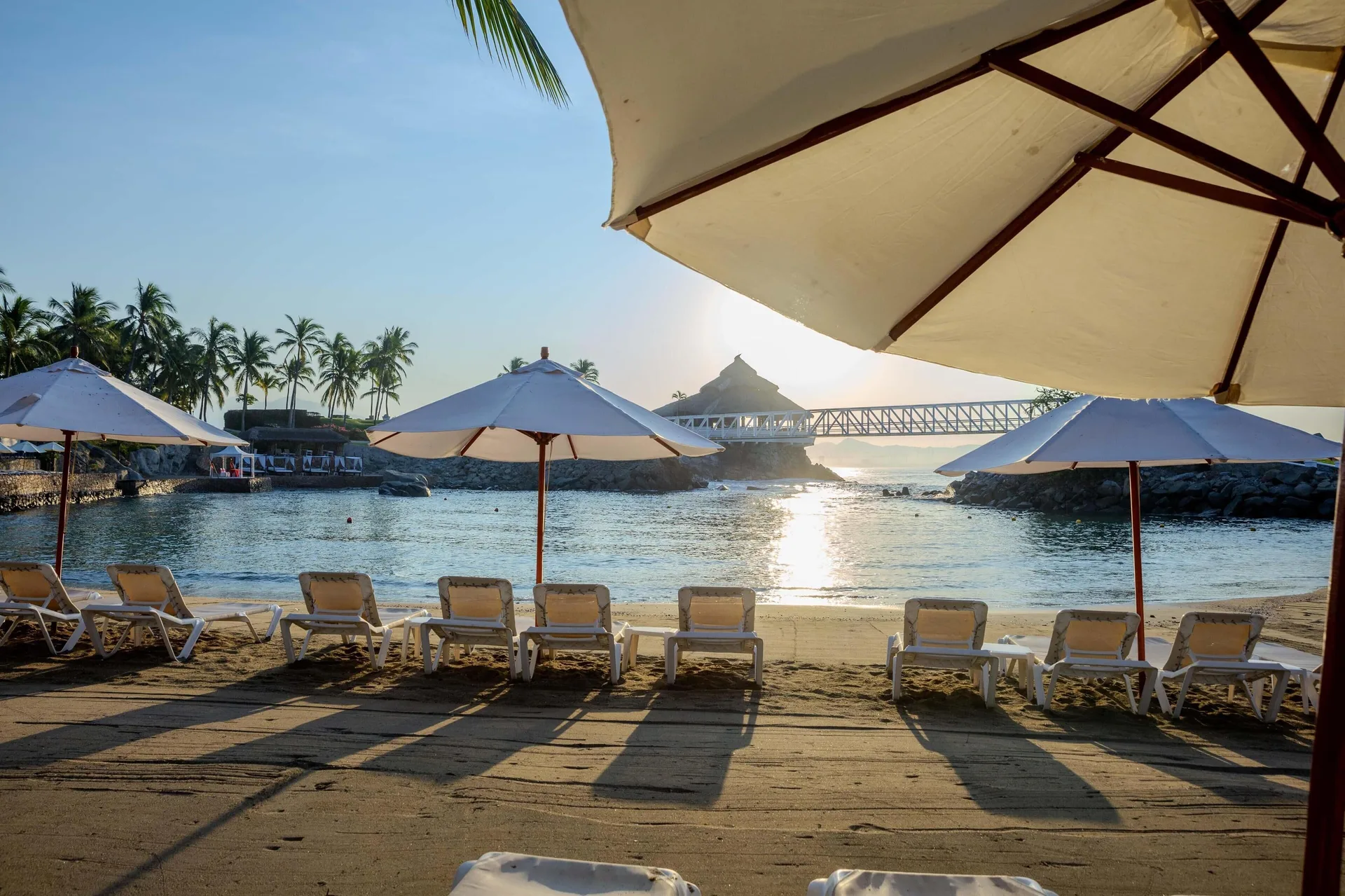 Beach loungers and umbrellas face the sheltered cove at Barceló Karmina.