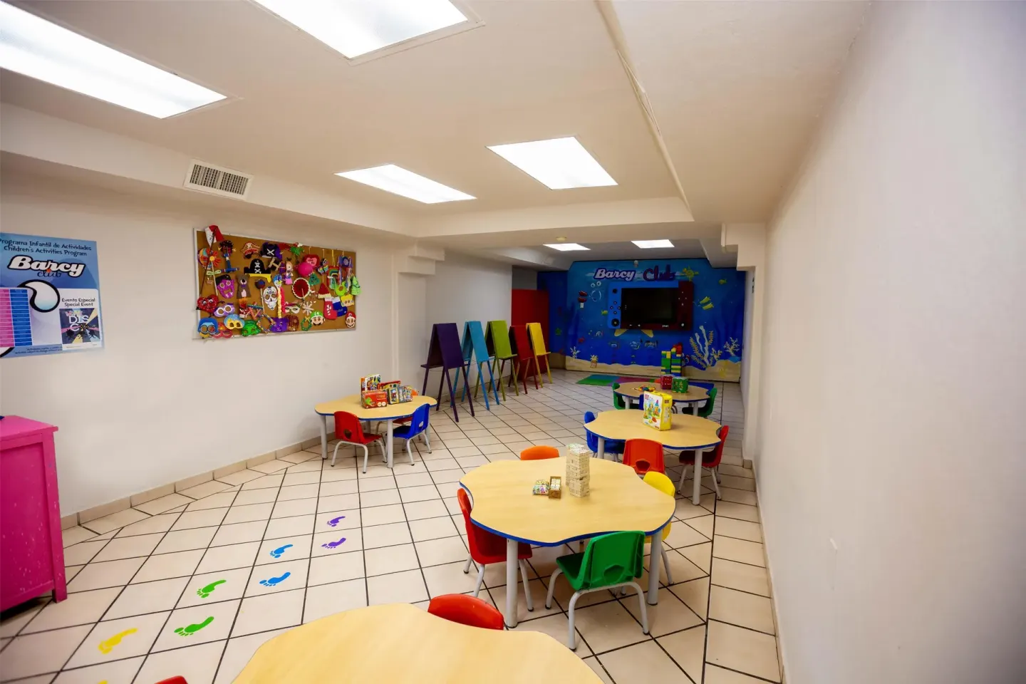 Children's activity room with small tables and colorful chairs at Barceló Karmina.