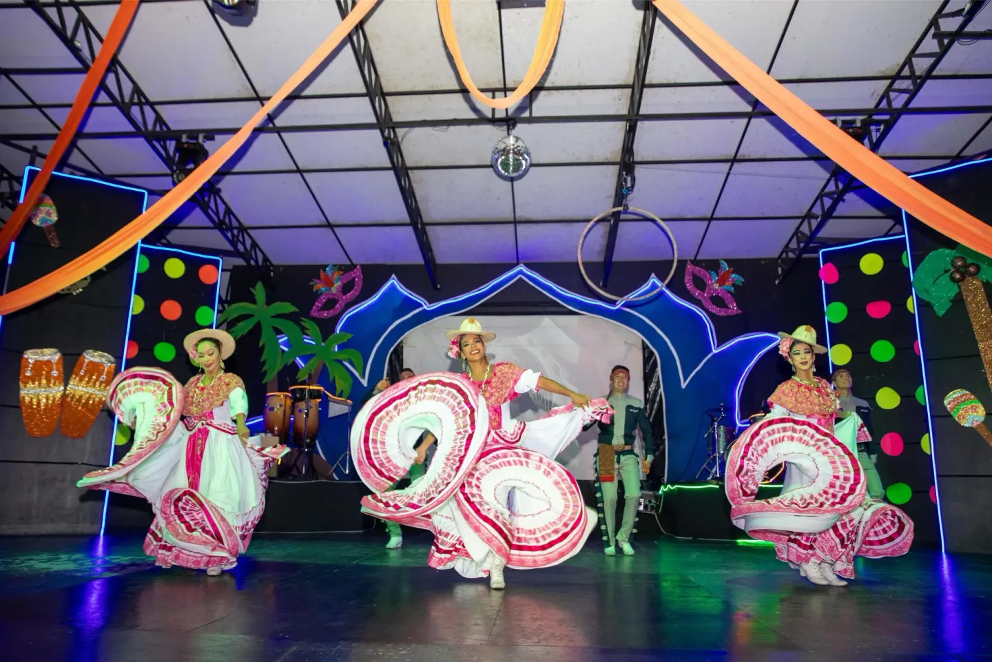 Dancers in colorful folkloric costumes perform on stage at Barceló Karmina.