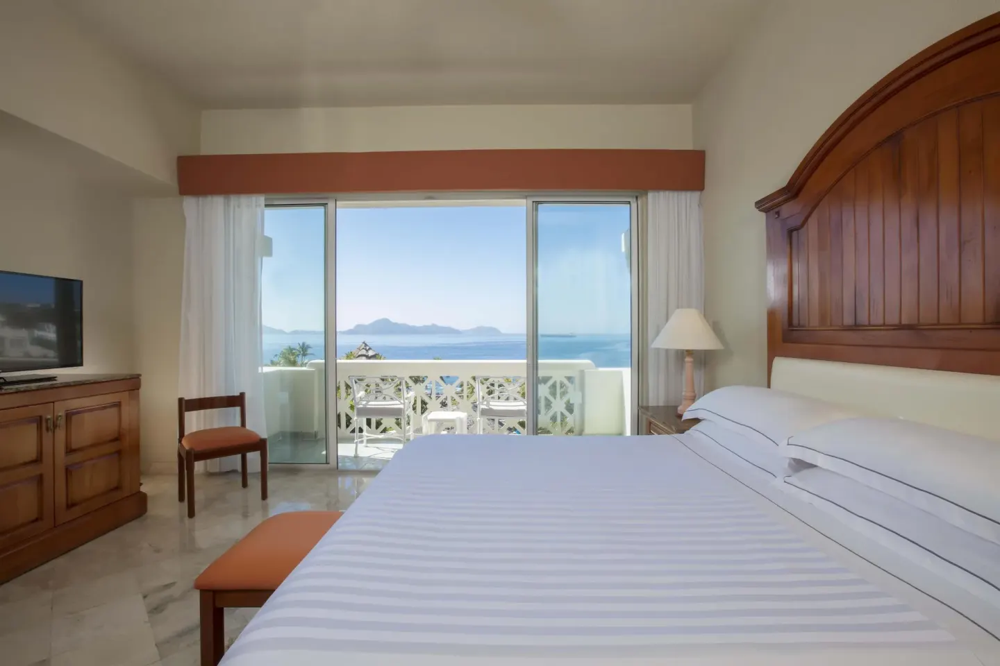 Guest room with king bed, balcony and ocean view at Barceló Karmina.