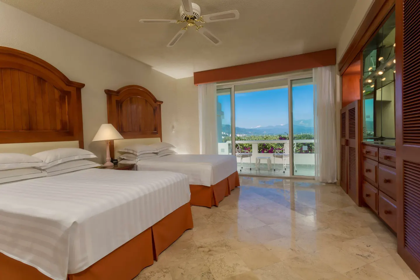 Guest room with two beds, balcony doors and mountain view at Barceló Karmina.